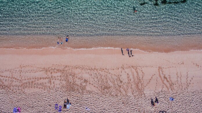 Students strolling on sandy beach near coastal universities | UniHomes | PBSA News Students strolling on sandy beach near coastal universities | UniHomes | PBSA News