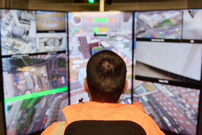 Crane operator in front of the Skyline Cockpit ground command centre’s panoramic screens at Winvic's Crown Place Birmingham project | PBSA News Crane operator in front of the Skyline Cockpit ground command centre’s panoramic screens at Winvic's Crown Place Birmingham project | PBSA News